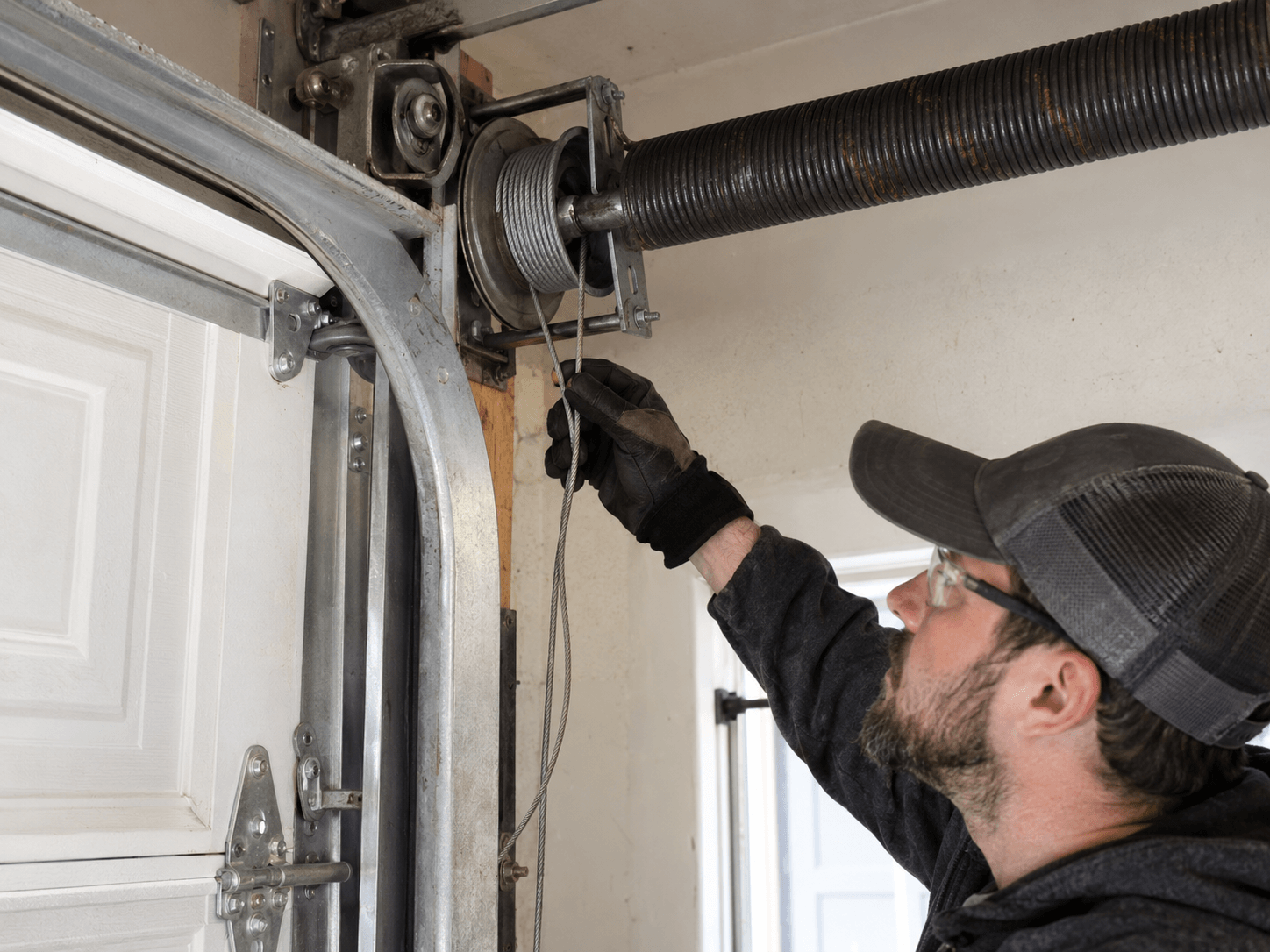 Garage door lift cable off the cable drum causing uneven door movement in South Houston TX